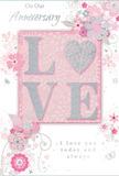 This softly romantic anniversary card feels like a visual whisper of devotion, blending pastel tones and delicate details with the ease of a florist crafting a favourite couple's yearly bouquet in Worcester Park. The focal point is the word "LOVE," set in gentle, raised lettering that has been dusted with fine, silver-tinted glitter. Each letter glows subtly, while the letter "O" is replaced by a shimmering heart, its densely textured surface catching the light like a polished charm in a cherished jewellery box. The background is composed of muted pinks and silvery greys, merging into a smooth, velvety field that immediately suggests intimacy and warmth. Around this central motif, a constellation of delicate blooms unfurls-petals in blush, mauve, and soft ivory with an almost watercolor softness, outlined by the finest of lines. Slender vines, tiny swirls, drifting petals, and a few discreet butterflies weave between the flowers, adding a sense of gentle motion, as if a light spring breeze from nearby parks were stirring the design. The text "On Our Anniversary" and "I love you today and always," or similar wording, appears in a graceful, flowing script that seems handwritten, reinforcing the authenticity of the sentiment. The card's tactile details invite touch, much as fresh petals do when arranging stems for a home near Central Road or Old Malden. Overall, the composition conveys a quiet yet profound celebration of shared years and memories-a keepsake that feels as thoughtfully composed as a bespoke anniversary arrangement delivered locally around Worcester Park.